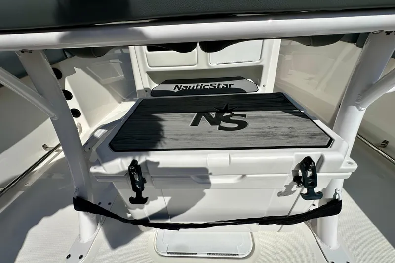 Slide: The Image of 2024 NauticStar 22XS boat interior with storage compartment and logo. - 14