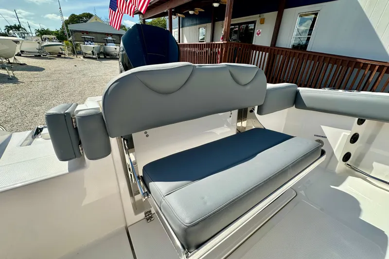 Slide: The Image of 2024 NauticStar 22XS boat interior with gray seating and American flag in background. - 19