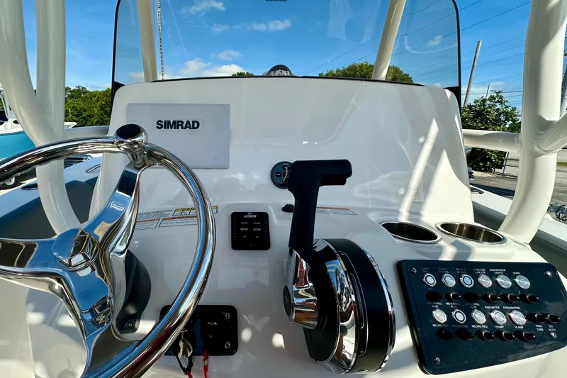 Slide: The Image of 2024 NauticStar 22XS boat dashboard with steering wheel and control panel. - 21