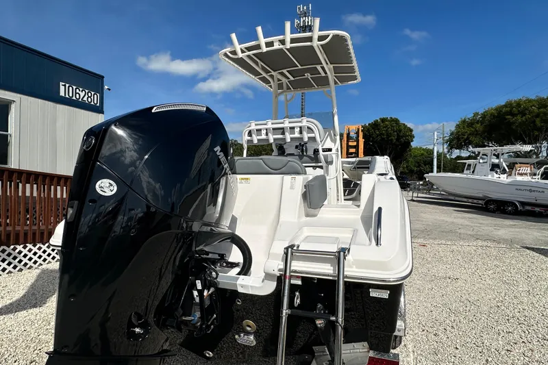 Slide: The Image of 2024 NauticStar 22XS boat with powerful outboard motor, parked outdoors under clear blue sky. - 3