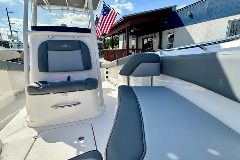Slide: The Image of 2024 NauticStar 22XS boat interior with gray seating and American flag in background. - 8