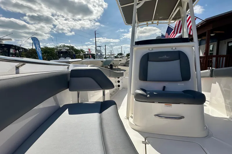 Slide: The Image of 2024 NauticStar 22XS boat interior with seating, under a sunny sky. - 9