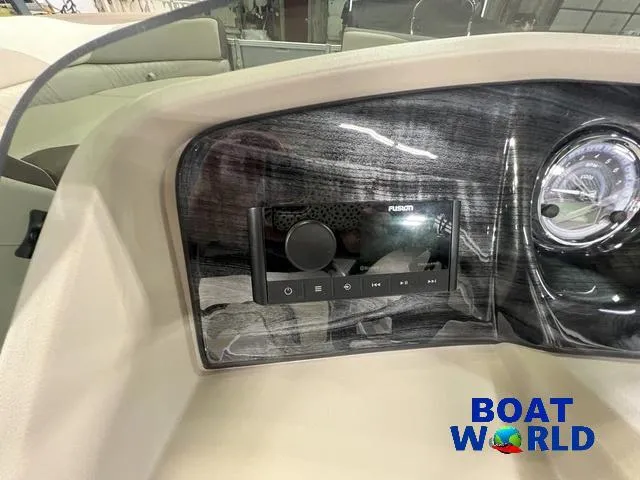 Slide: The Image of 2025 Tahoe LTZ 2385 Elite Cruise Tritoon dashboard with Fusion stereo system, Boat World logo. - 12