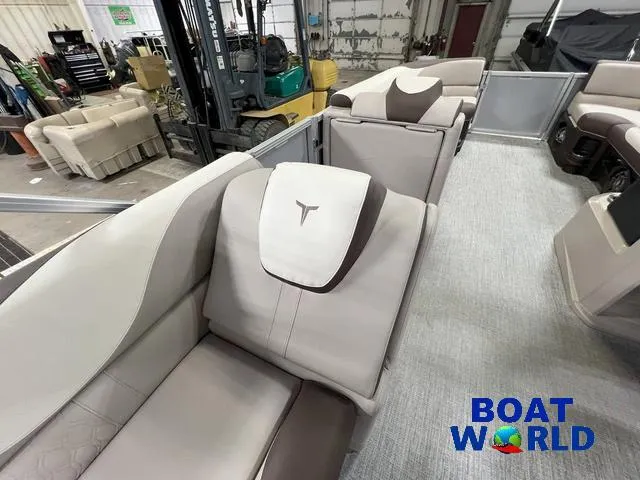 Slide: The Image of 2025 Tahoe LTZ 2385 Elite Cruise Tritoon interior with plush seating, showcased at Boat World. - 17