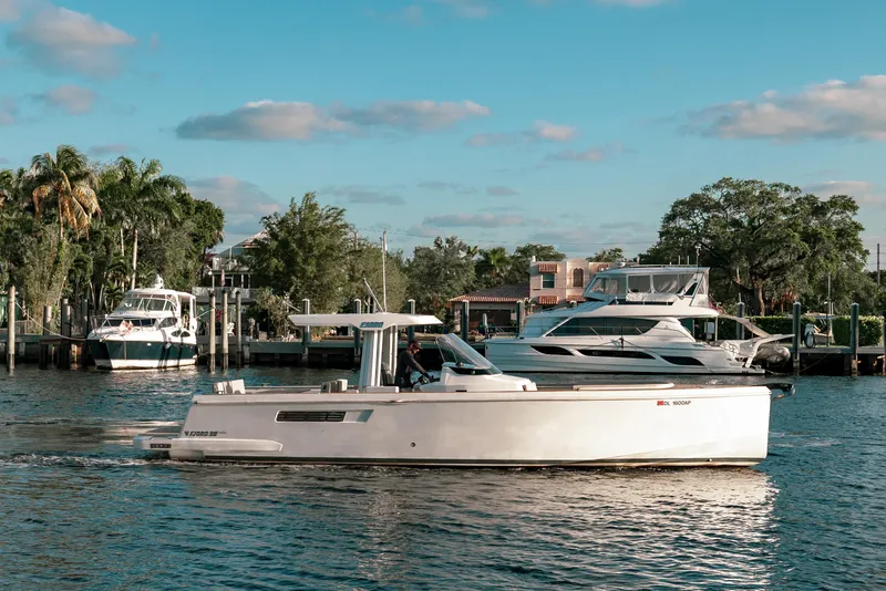 Slide: The Image of 2022 Fjord 38 Open yacht cruising on a scenic waterfront with other boats. - 10