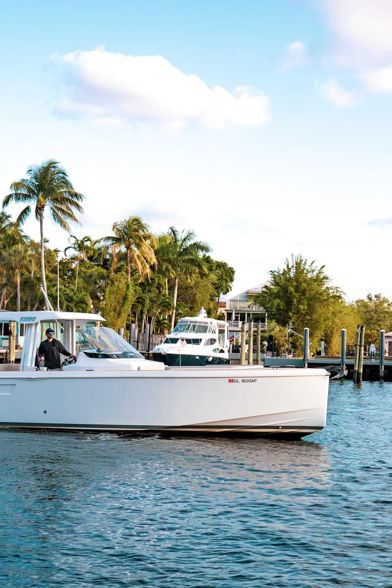 Slide: The Image of 2022 Fjord 38 Open boat cruising near palm-lined marina. - 17