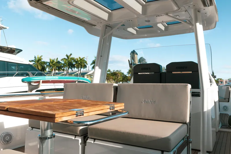 Slide: The Image of 2022 Fjord 38 Open yacht interior with seating and table, docked under clear skies. - 22