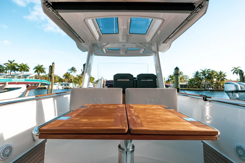 Slide: The Image of Fjord 38 Open 2022 boat with wooden table, docked near palm trees. - 23