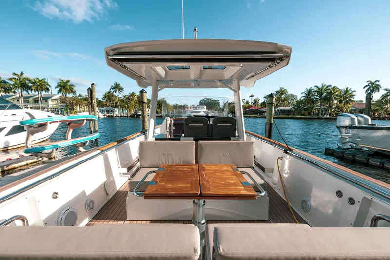 Slide: The Image of 2022 Fjord 38 Open yacht with spacious deck and seating, docked by palm trees. - 24