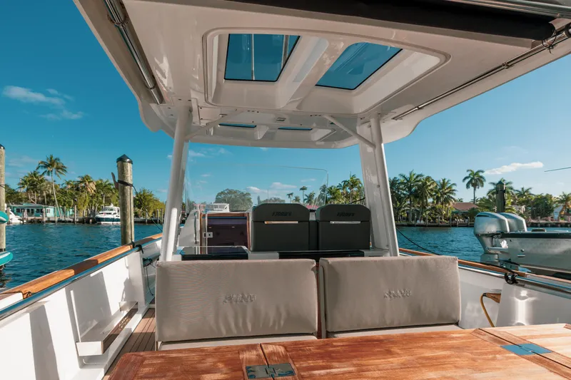 Slide: The Image of 2022 Fjord 38 Open boat interior with sunroof, docked by palm trees and clear blue sky. - 29