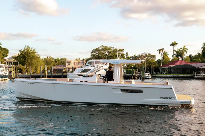 Slide: The Image of 2022 Fjord 38 Open yacht cruising on a sunny day near waterfront homes. - 3