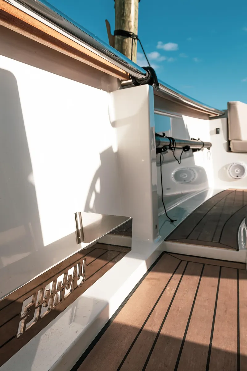 Slide: The Image of 2022 Fjord 38 Open boat deck with sleek wood finish and modern design. - 35
