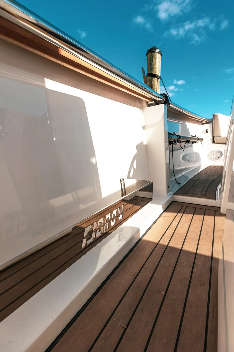 Slide: The Image of 2022 Fjord 38 Open yacht deck with wooden flooring and clear blue sky. - 36