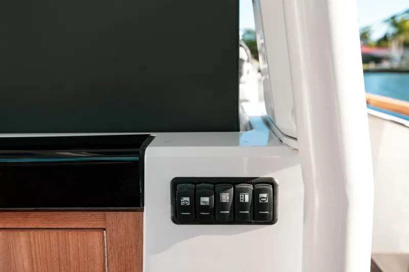 Slide: The Image of Control panel on 2022 Fjord 38 Open yacht, featuring sleek design and wooden accents. - 38
