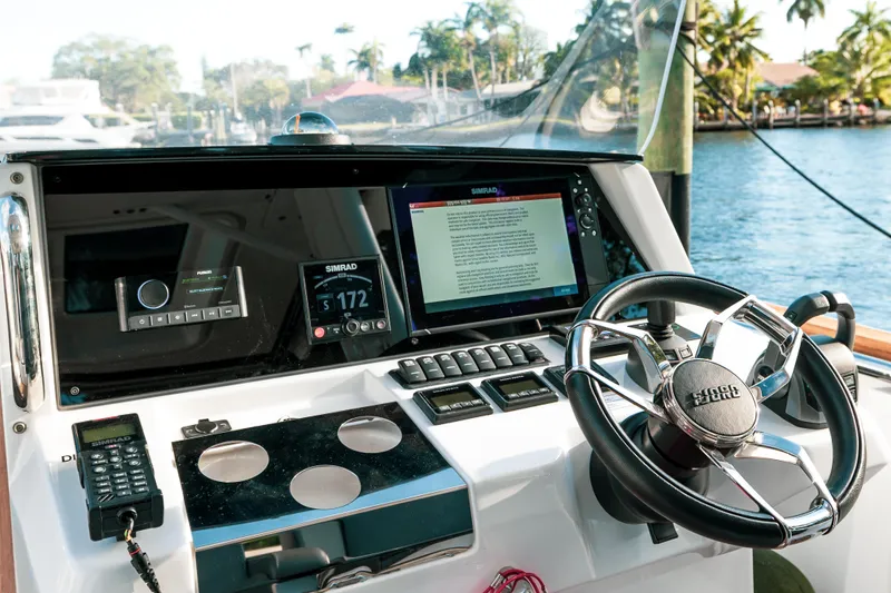 Slide: The Image of 2022 Fjord 38 Open boat dashboard with steering wheel and navigation screens. - 45