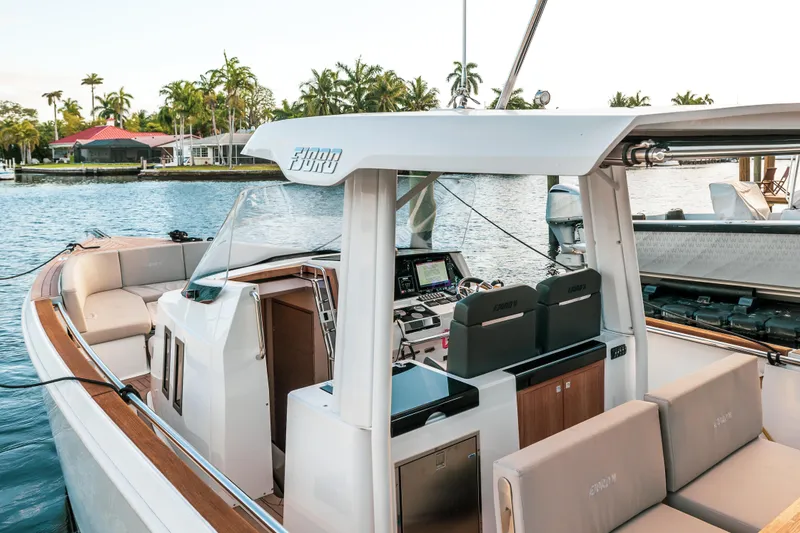 Slide: The Image of 2022 Fjord 38 Open yacht interior with modern seating and controls, docked by the water. - 49