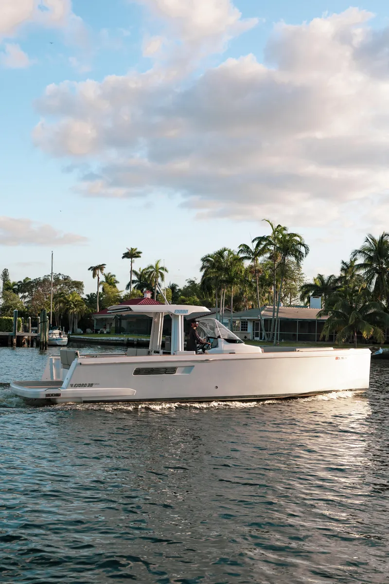 Slide: The Image of 2022 Fjord 38 Open yacht cruising on a scenic waterway with palm trees. - 8