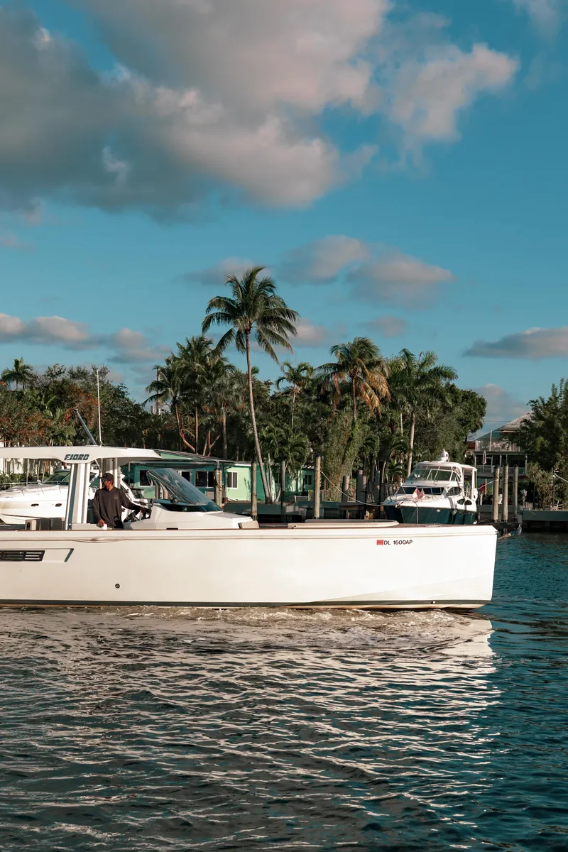 Slide: The Image of 2022 Fjord 38 Open yacht cruising on a sunny day with palm trees in the background. - 9