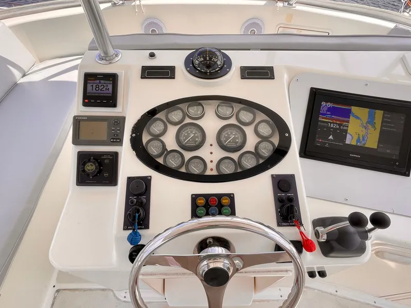 Slide: The Image of Control panel of 2000 Ocean Yachts 43 Super Sport with navigation instruments and steering wheel. - 21