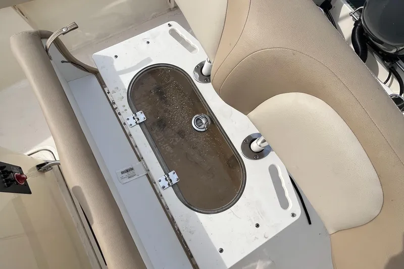 Slide: The Image of 2024 Scout 195 Sportfish boat interior with beige seating and storage compartment. - 11