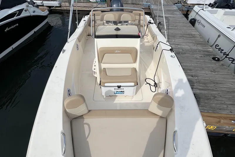 Slide: The Image of 2024 Scout 195 Sportfish boat docked, featuring beige seating and sleek design. - 17