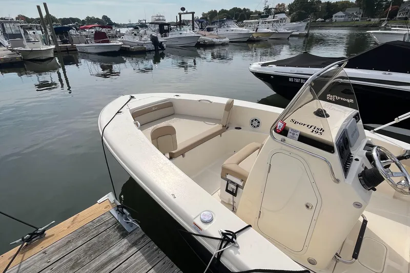 Slide: The Image of 2024 Scout 195 Sportfish boat docked at marina, surrounded by other boats. - 18