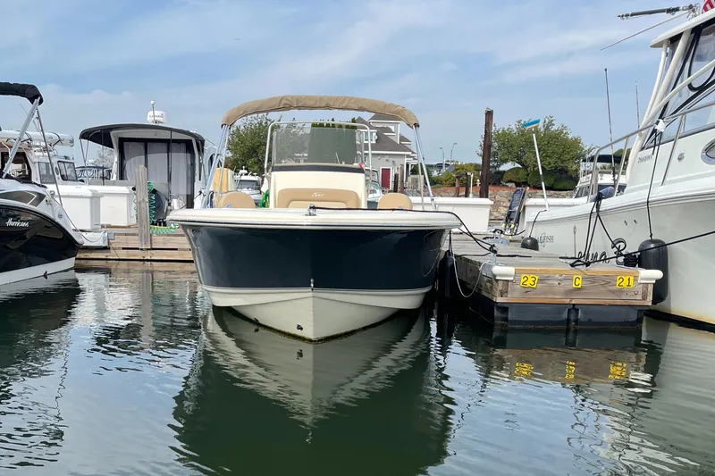 Slide: The Image of 2024 Scout 195 Sportfish boat docked in marina, front view. - 2
