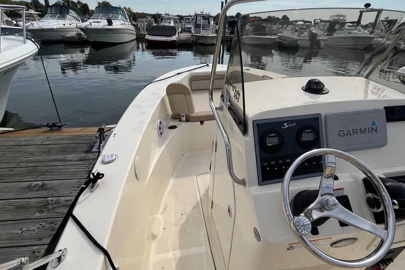 Slide: The Image of 2024 Scout 195 Sportfish boat docked at marina, featuring Garmin navigation system. - 9