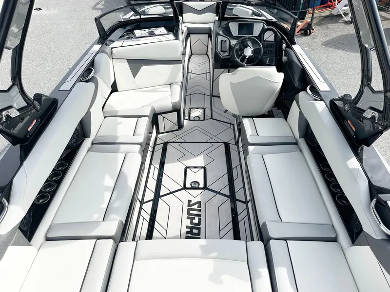 Slide: The Image of 2024 Supreme S240 boat interior with sleek white seating and modern dashboard design. - 7
