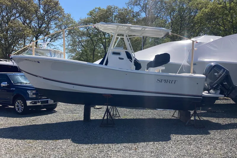 Slide: The Image of 2017 Regulator 23 Forward Seating boat on stands, outdoors, with trees in the background. - 0