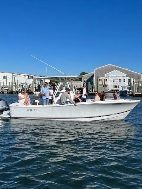 Slide: The Image of 2017 Regulator 23 Forward Seating boat with passengers on a sunny day near docks. - 10