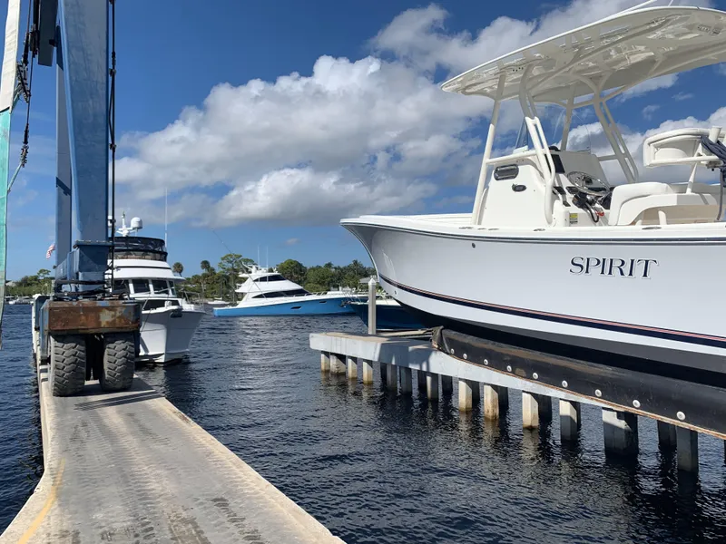 Slide: The Image of 2017 Regulator 23 Forward Seating boat docked, with other boats in a sunny marina. - 4
