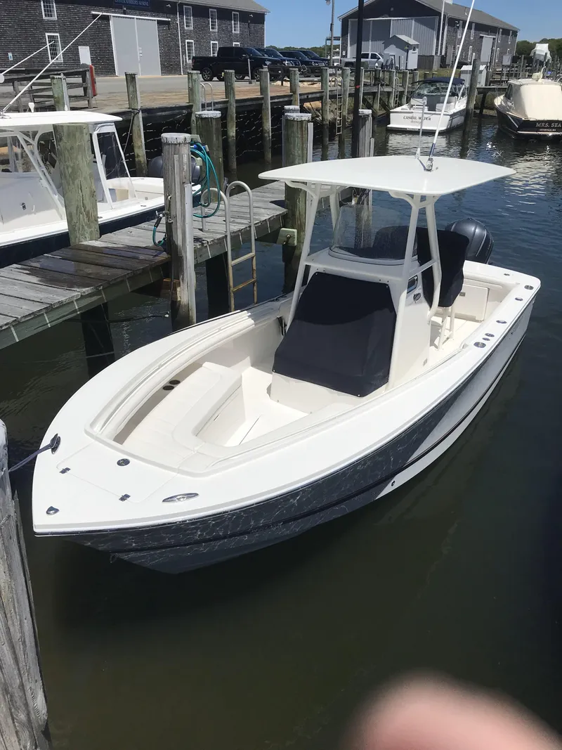 Slide: The Image of 2017 Regulator 23 Forward Seating boat docked in a marina. - 6