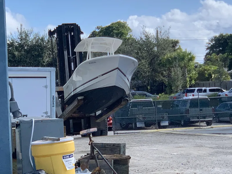 Slide: The Image of 2017 Regulator 23 Forward Seating boat on forklift in outdoor storage area. - 7