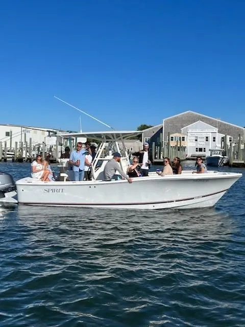 Slide: The Image of 2017 Regulator 23 Forward Seating boat with passengers on a sunny day near docks. - 9