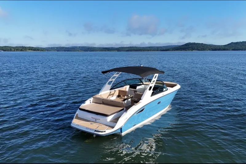 Slide: The Image of 2025 Sea Ray SDX 270 boat on a serene lake with distant hills. - 12