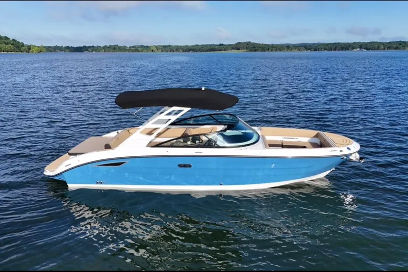Slide: The Image of 2025 Sea Ray SDX 270 boat on a calm lake with blue skies. - 13