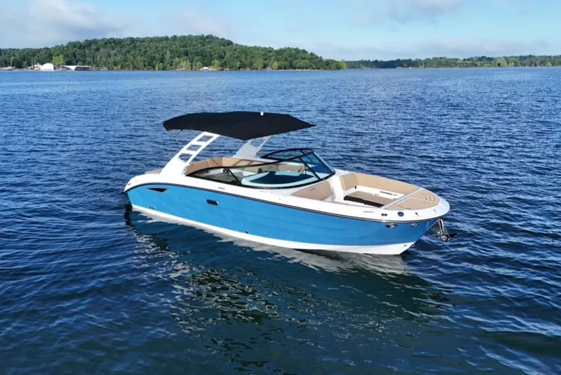 Slide: The Image of 2025 Sea Ray SDX 270 boat on a serene lake with lush green shoreline. - 14