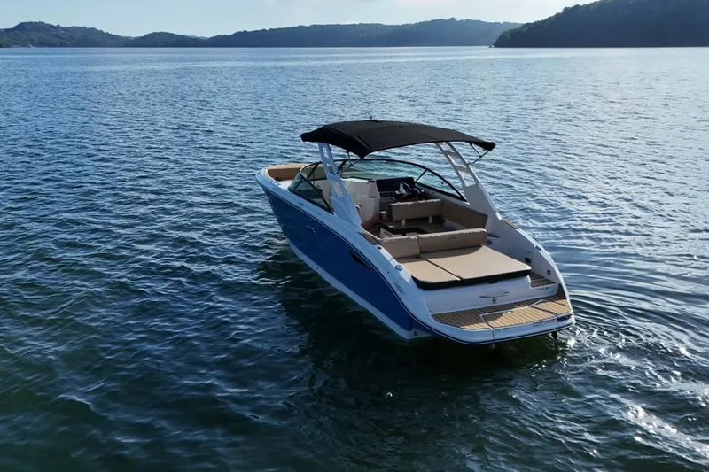 Slide: The Image of 2025 Sea Ray SDX 270 boat on calm water with scenic background. - 16