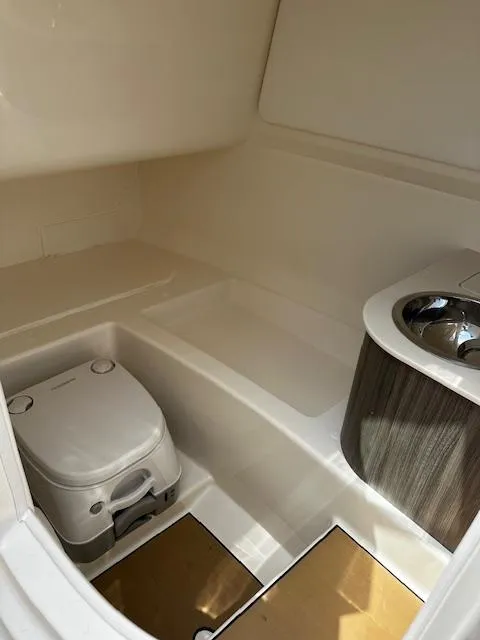 Slide: The Image of 2025 Sea Ray SDX 270 boat interior with compact toilet and sink. - 6