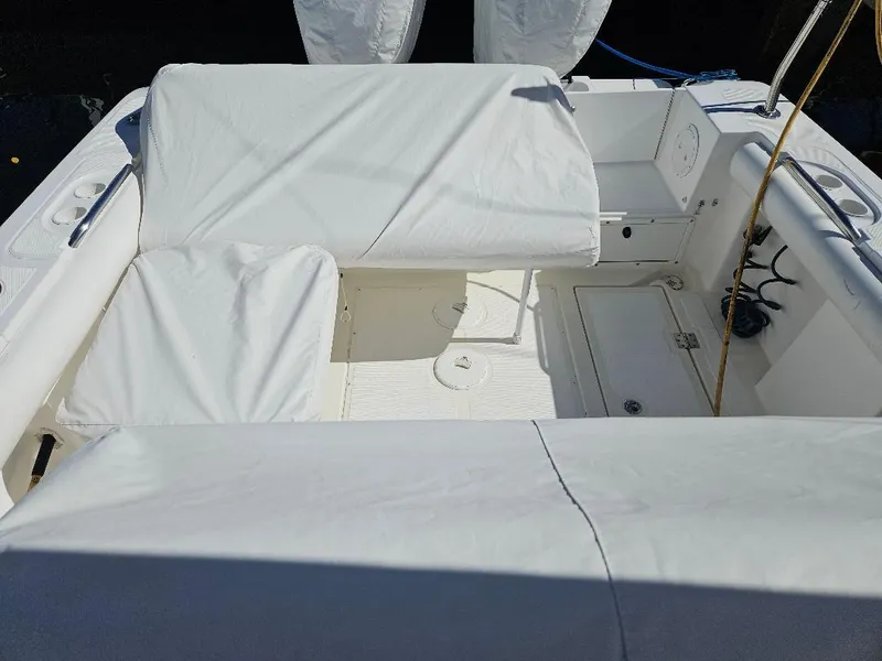 Slide: The Image of 2004 Marlago FS35 boat interior with white cushioned seating and storage compartments. - 11