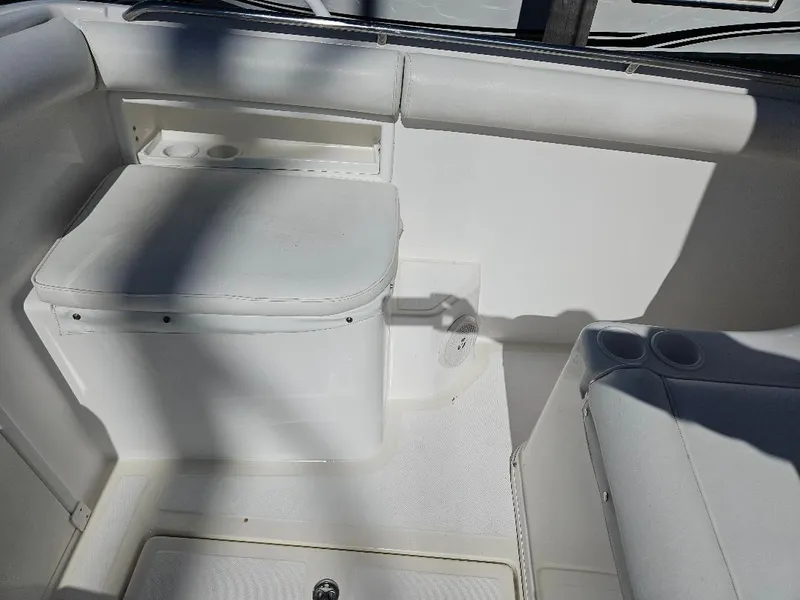 Slide: The Image of 2004 Marlago FS35 boat interior with white seating and storage compartment. - 13