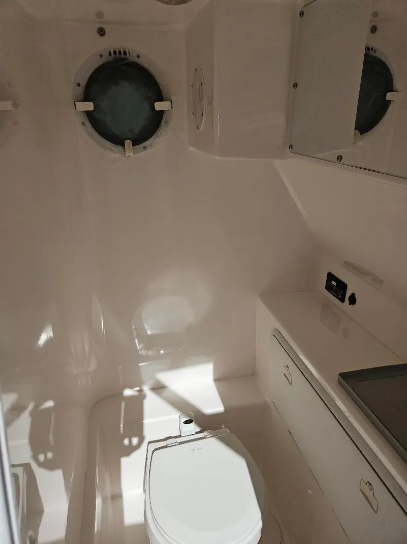 Slide: The Image of 2004 Marlago FS35 boat bathroom with porthole and storage cabinets. - 16