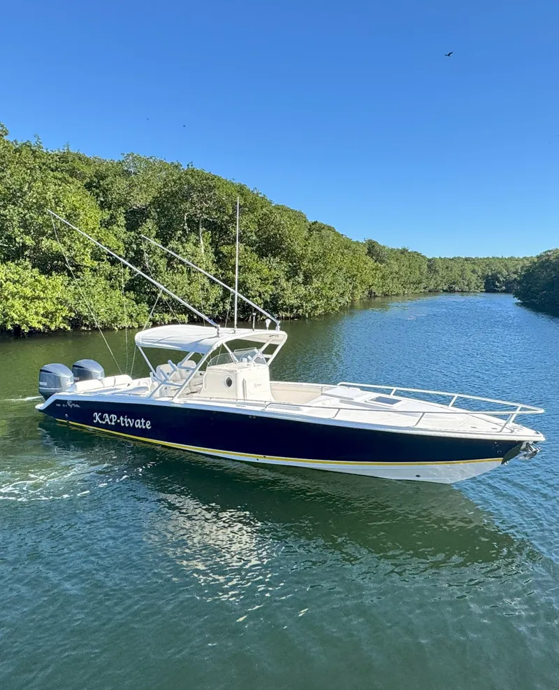 Slide: The Image of 2004 Marlago FS35 boat cruising on a scenic river with lush greenery. - 2