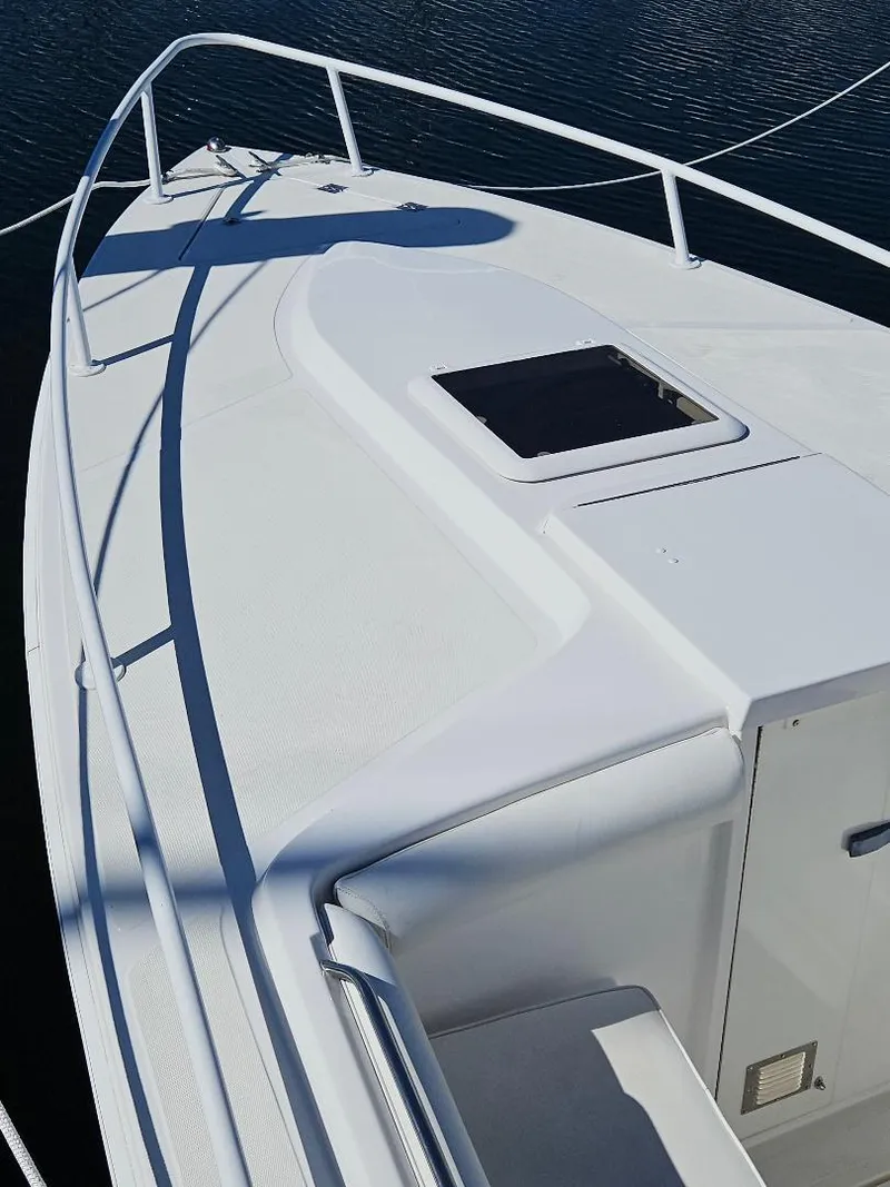 Slide: The Image of 2004 Marlago FS35 boat deck with railing and hatch, on calm water. - 24