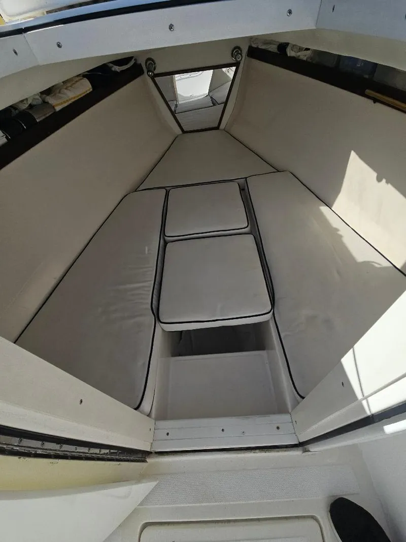 Slide: The Image of 2004 Marlago FS35 boat interior with cushioned seating and storage. - 25