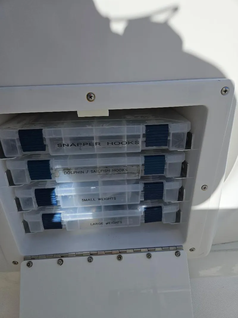 Slide: The Image of Fishing tackle storage on a 2004 Marlago FS35 boat, featuring organized snapper hooks and weights. - 31