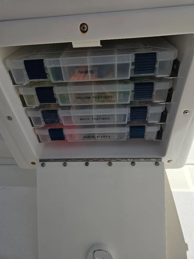Slide: The Image of Storage compartment with labeled tackle boxes on a 2004 Marlago FS35 boat. - 32