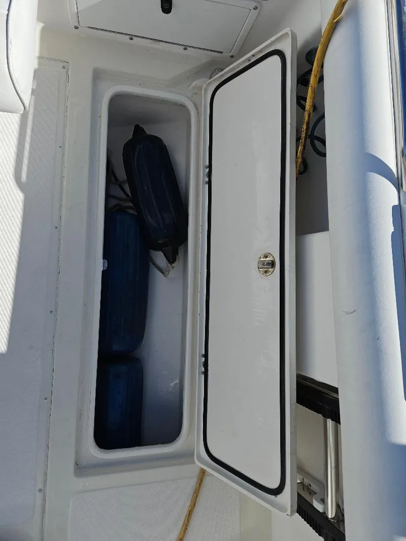 Slide: The Image of Open storage compartment on 2004 Marlago FS35 boat with bags inside. - 33