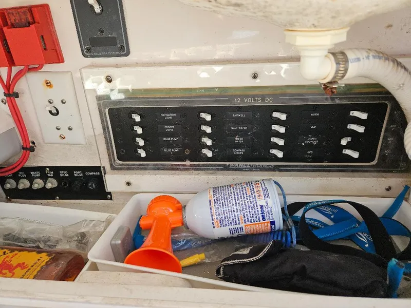 Slide: The Image of Control panel and storage area of a 2004 Marlago FS35 boat, featuring switches and safety equipment. - 35